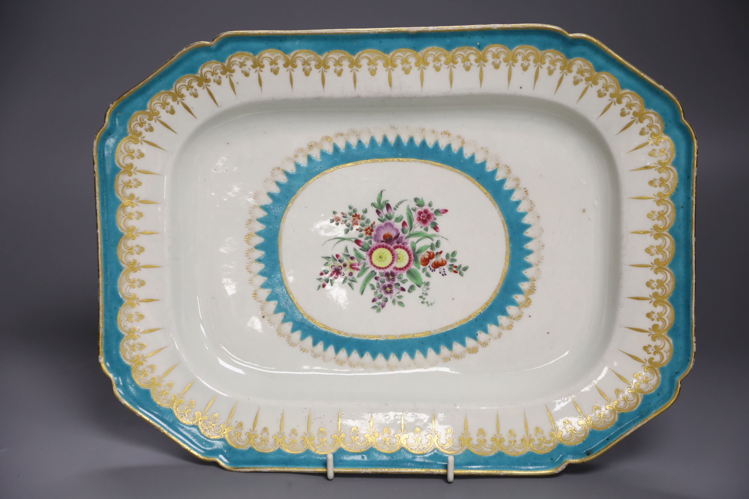 A Worcester canted platter or serving dish painted with flowers within a gilt and turquoise sawtooth border, c. 1770, length 33.5cm